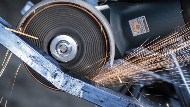 금속 막대를 자르는 절단 휠이 밝은 불꽃을 냅니다.
