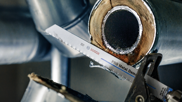 왕복 톱날로 금속 파이프를 절단합니다.