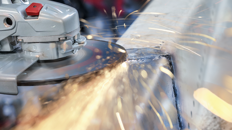 각도 분쇄기로 금속을 절단하여 불꽃을 생성합니다.