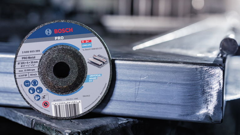 작업장의 반짝이는 금속 들보 위에 절단 디스크를 세워 놓은 모습입니다.