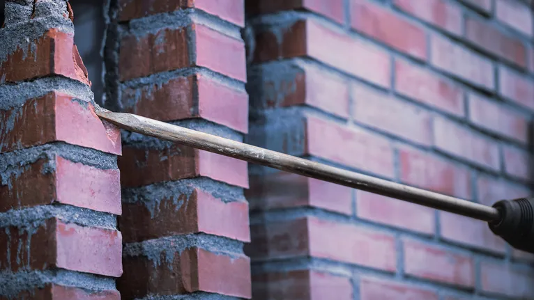 벽돌 벽에 구멍을 뚫는 드릴 비트입니다.