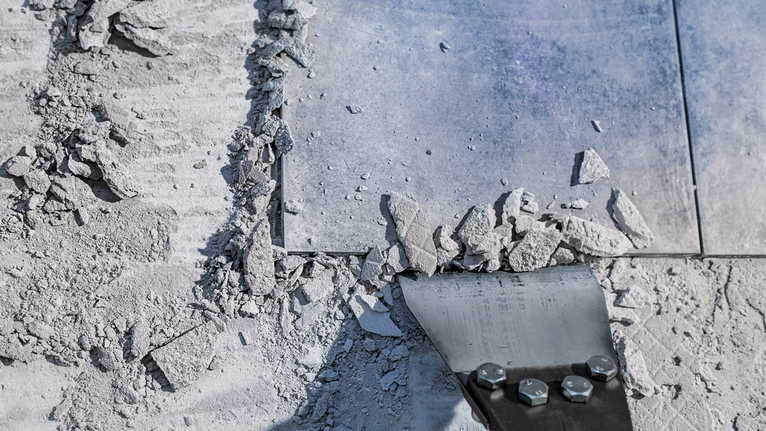 먼지가 쌓인 바닥의 세라믹 타일과 잔해물을 부수는 끌 도구입니다.