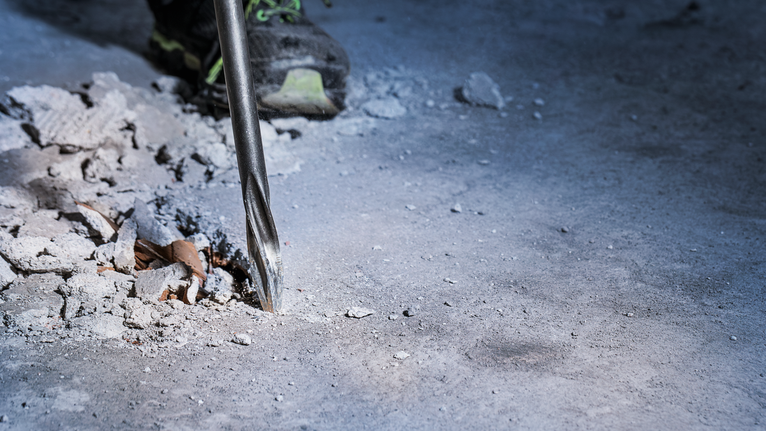 PRO SDS max-5C 플랫 치즐, 25 x 400mm 콘크리트 바닥을 뚫고 있는 회전 해머 드릴입니다.