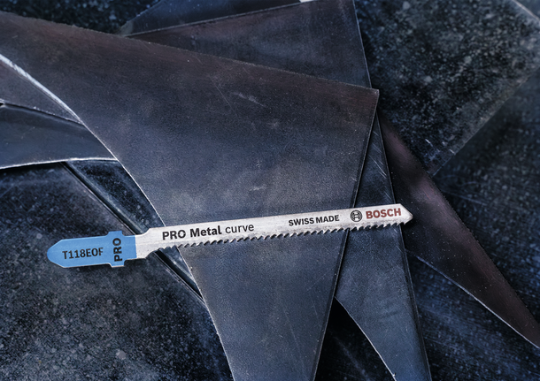 PRO Metal curve T118EOF 직쏘날, 83mm, 5개 금속 퍼즐 칼날이 쌓인 판금 조각 위에 놓여 있습니다.