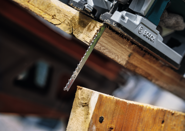 작업장에서 두꺼운 나무 판자를 자르는 톱날.