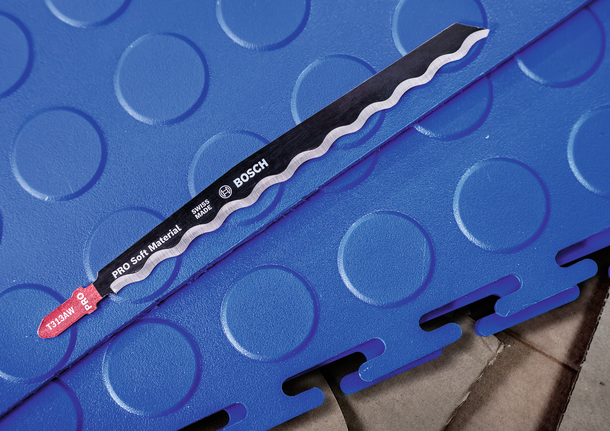 서로 맞물린 파란색 폼 바닥 위에 놓인 퍼즐 칼날.