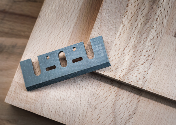 나무판 위에 올려진 금속 커터 칼날.