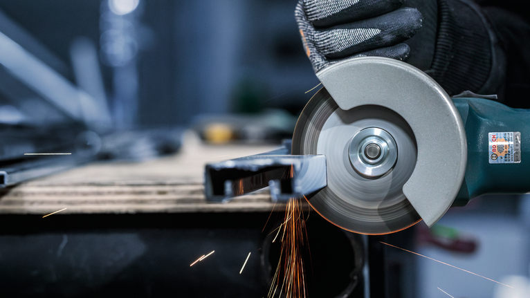 PRO Stainless Steel and Metal 절단석, 105 x 1 x 16mm 안전 장비를 착용한 사람이 각도 분쇄기를 사용하여 금속을 절단하면서 불꽃을 일으킵니다.