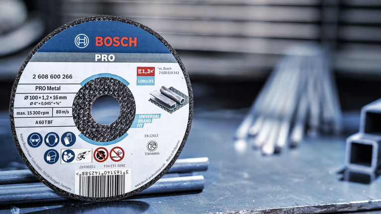 작업장의 강철 막대 옆 작업대 위에 금속 절단 디스크가 놓여 있습니다.