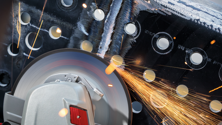 천공된 금속을 절삭 공구로 갈아내면서 불꽃이 튀었다.