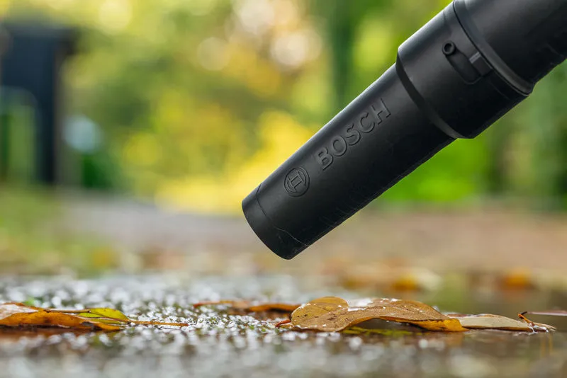 비가 내린 후 무선 송풍기로 길에서 젖은 나뭇잎을 치우는 모습입니다.