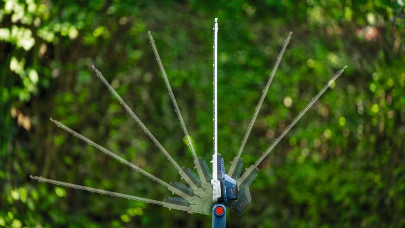 야외에서 조절 가능한 절단 각도를 보여주는 무선 망원 헤지커터입니다.