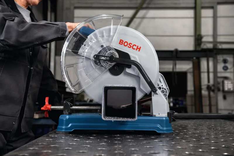 GCD 18V-355 안전 장비를 착용한 사람이 강철 파이프에서 금속 절단 톱을 조작하고 있습니다.