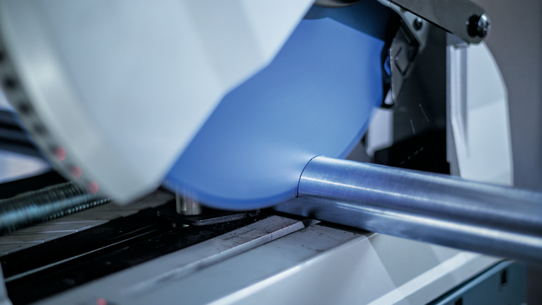 작업장에서 원형 톱날로 금속 파이프를 절단하고 있습니다.