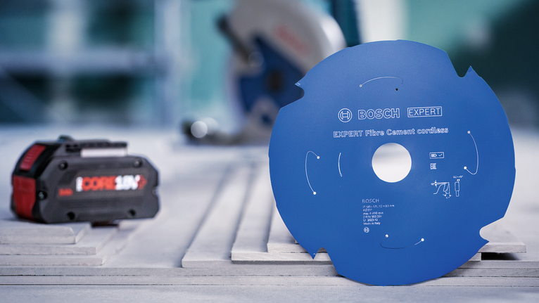 전동 공구 배터리 옆 작업대 위에 놓인 원형 톱날.