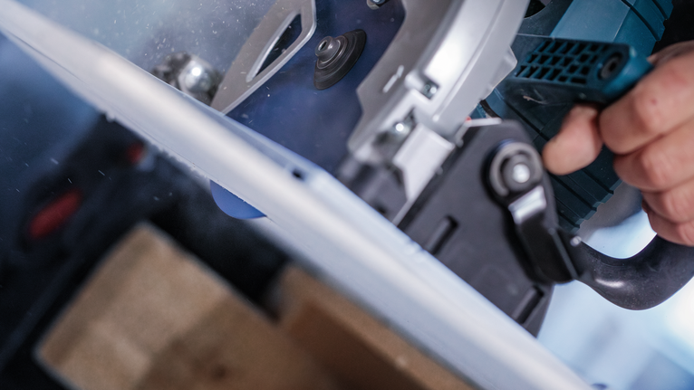 원형 톱을 조작하여 판자를 자르는 사람.