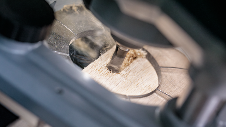 회전 공구로 나무판에 정밀한 구멍을 뚫습니다.