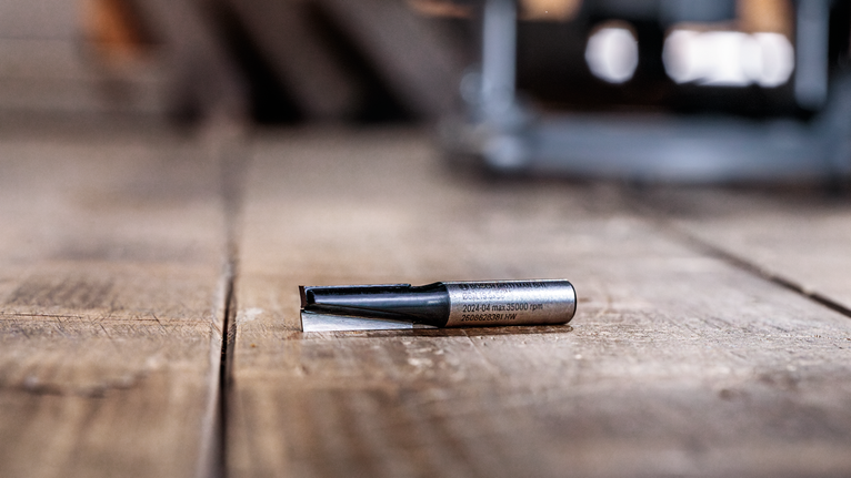 작업장 내 나무 표면 위에 놓인 라우터 비트입니다.