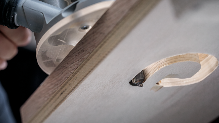 나무판에 정확한 원형 구멍을 조각하는 목공 라우터입니다.