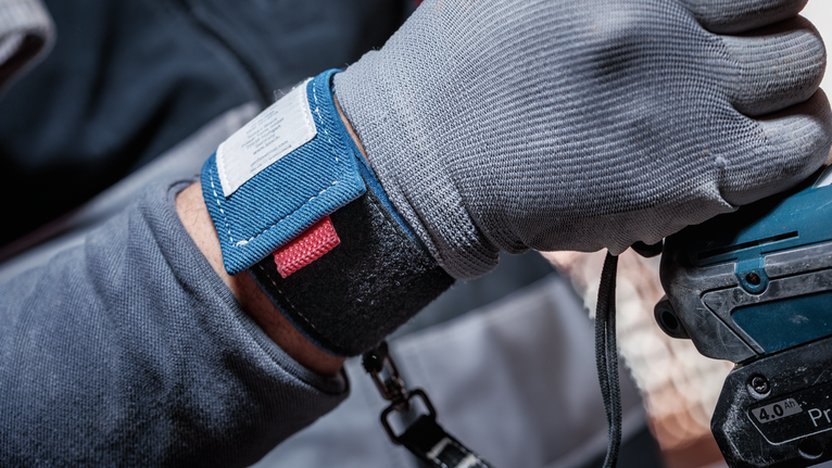 안전 장비를 착용한 사람이 전동 공구를 조작합니다.