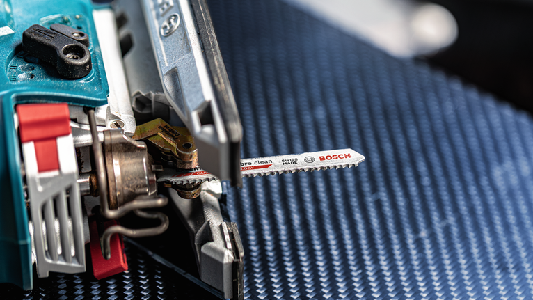 질감이 있는 파란색 표면 위에 금속 칼날이 올려진 퍼즐입니다.