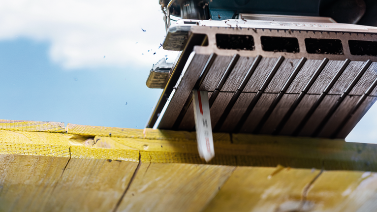 EXPERT Plastic Composites clean T301CHM 직쏘날, 3개 톱날이 밝은 야외 조명 아래에서 나무 들보를 자릅니다.