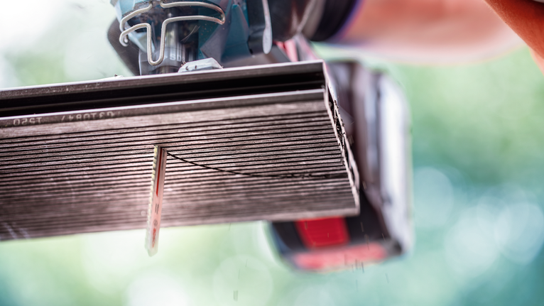 EXPERT Plastic Composites clean T301CHM 직쏘날, 3개 안전 장비를 착용한 사람이 전기톱을 사용해 세라믹 타일을 자르고 있습니다.