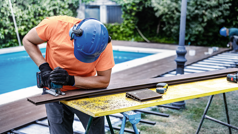 EXPERT Plastic Composites clean T301CHM 직쏘날, 3개 안전 장비를 착용한 사람이 톱을 사용하여 야외에서 데크 보드를 자르고 있습니다.