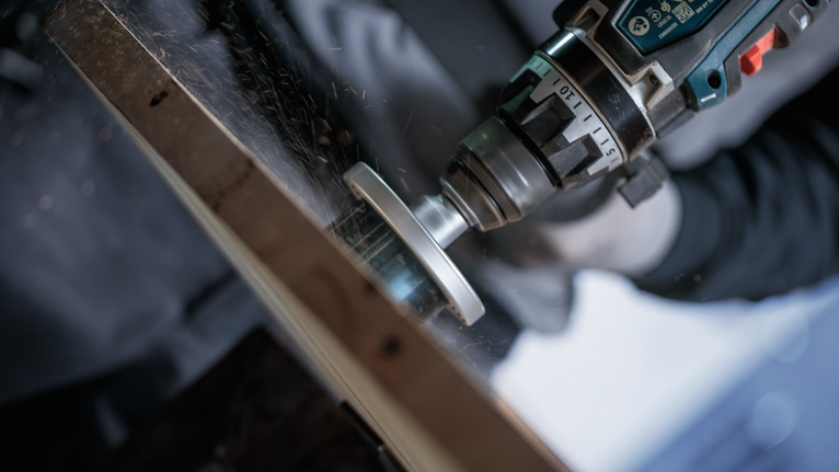 안전 장비를 착용한 사람이 금속을 갈아 불꽃을 일으키고 있습니다.