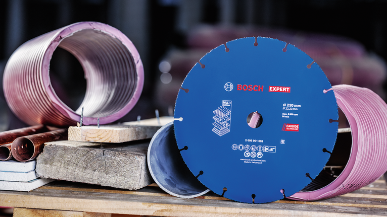 금속과 콘크리트 코어 샘플 옆 작업대에 전시된 다이아몬드 톱날입니다.