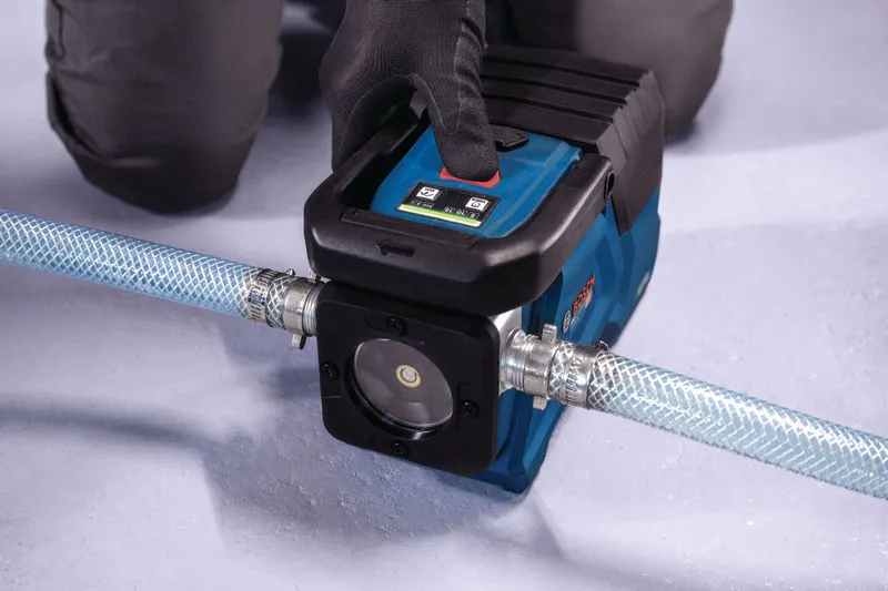 안전 장비를 착용한 사람이 호스에 연결된 휴대용 물 펌프를 작동하고 있습니다.