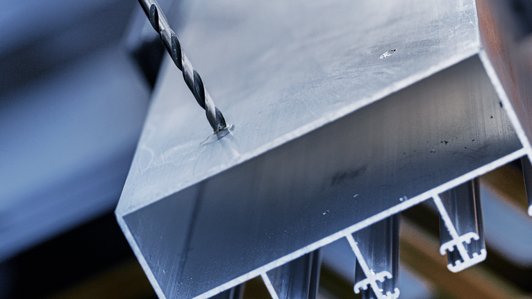 금속 빔에 구멍을 뚫는 드릴 비트입니다.