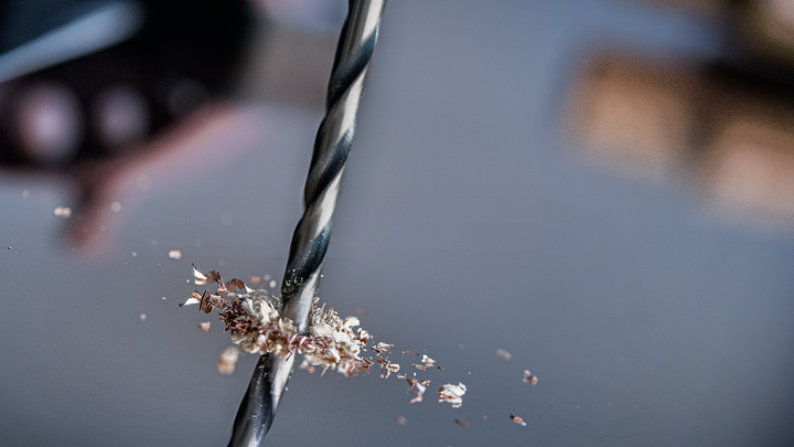 진입 지점 주위에 금속 부스러기를 사용하여 금속에 구멍을 뚫는 드릴 비트입니다.