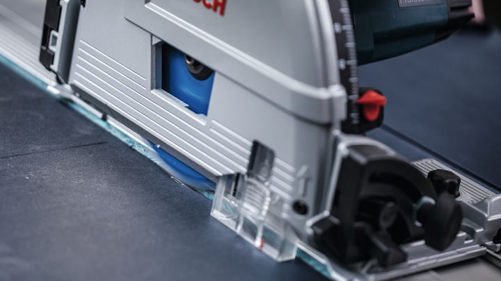 원형 톱으로 어두운 색 시트 소재를 정밀하게 절단합니다.