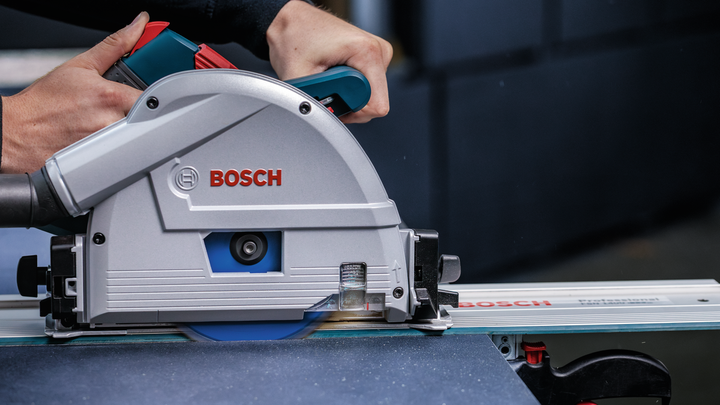 사람이 원형 톱을 궤도를 따라 움직여서 재료 시트를 자릅니다.