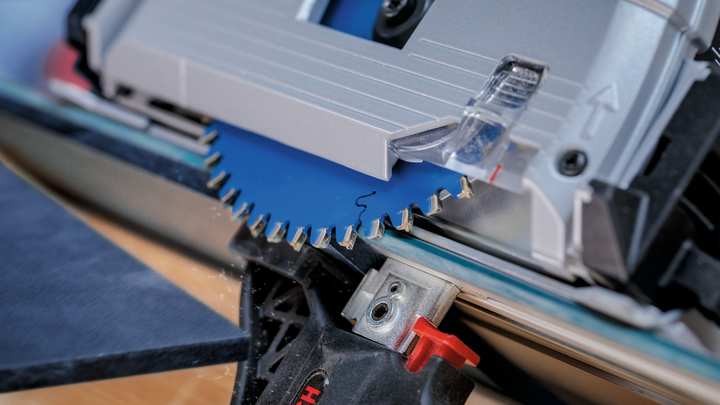 원형 톱날로 나무판을 자르고 있습니다.