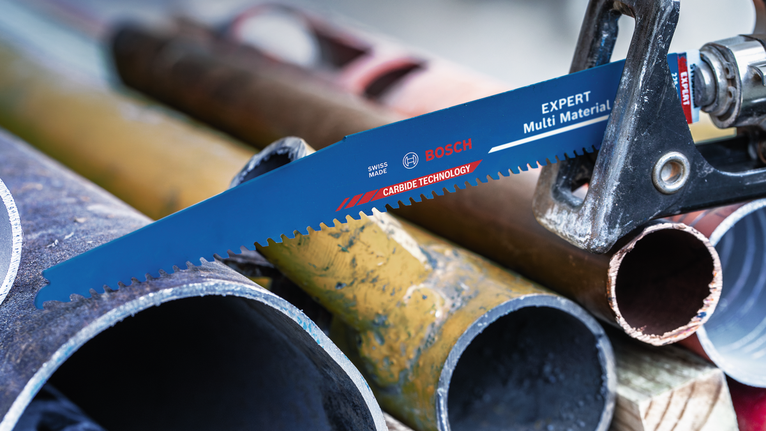 산업 현장에서 톱날이 금속 파이프를 절단하는 모습.