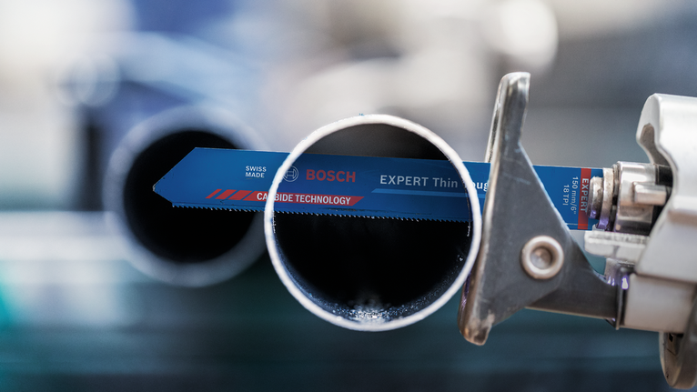 산업 현장에서 왕복톱날이 금속 파이프를 절단하는 모습.