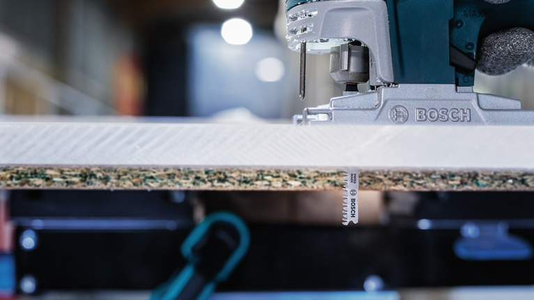 작업장에서 직소톱이 합판 패널을 자르고 있는 모습.