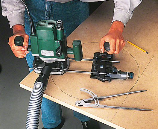 작업자는 가이드가 달린 라우터를 사용해 목재를 정확한 원 모양으로 자릅니다.