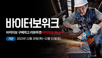 작업복을 입은 남성이 금속을 절단하고 있습니다. 배경은 작업장입니다.