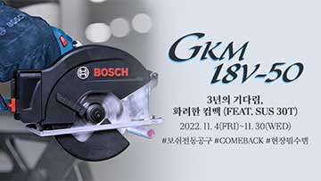 보쉬 GKM 18V-50 전기톱, 검은색, 작업 중인 손과 배경이 흐릿함.