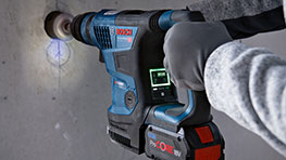 보쉬 프로페셔널 전동 드릴이 벽에 구멍을 뚫고 있는 모습.